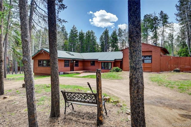 9123 Booker Ln, Conifer, CO 80433 - view of front of property with an attached garage, fence, metal roof, and dirt driveway