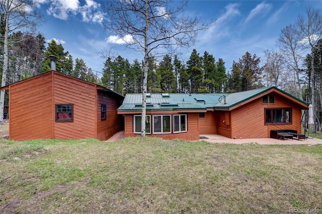 9123 Booker Ln, Conifer, CO 80433 - rear view of house featuring a lawn, a patio, and metal roof