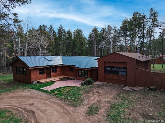 9123 Booker Ln, Conifer, CO 80433 - view of front of property featuring a garage, dirt driveway, and metal roof