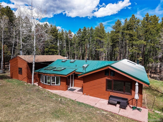 9123 Booker Ln, Conifer, CO 80433 - rustic home with a front yard, a metal roof, a patio, and a forest view