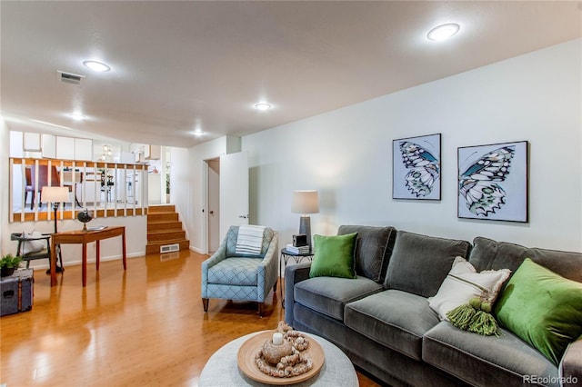 living room with lofted ceiling and light hardwood / wood-style flooring