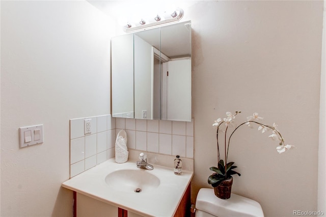 bathroom featuring vanity, backsplash, and toilet