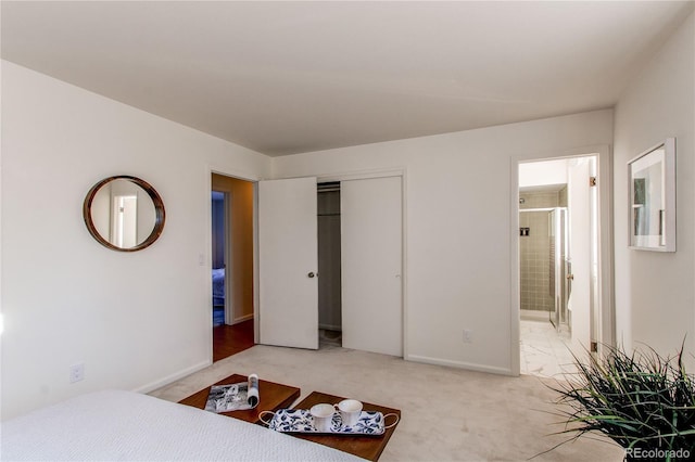 bedroom with ensuite bath, carpet floors, and a closet