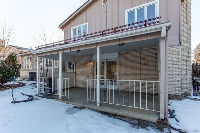 snow covered house with covered porch