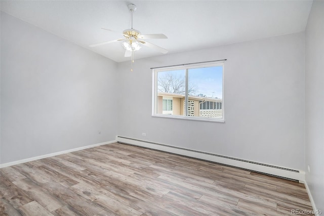 empty room featuring ceiling fan, baseboard heating, and light hardwood / wood-style flooring