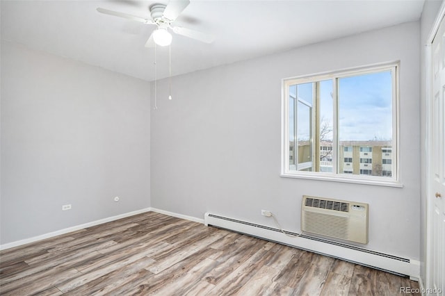 spare room with a baseboard heating unit, ceiling fan, and light wood-type flooring