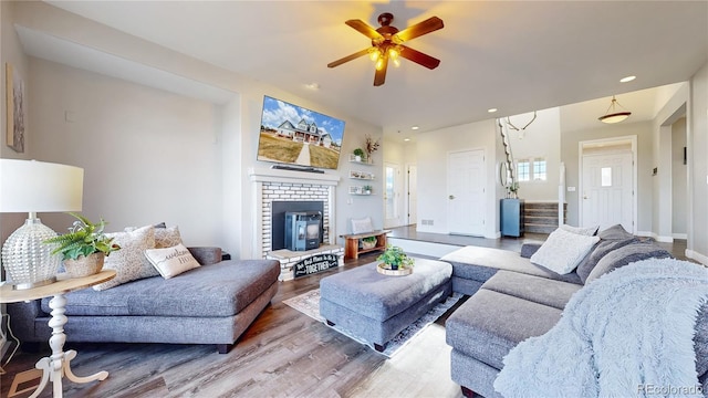 living room featuring baseboards, ceiling fan, stairway, wood finished floors, and recessed lighting