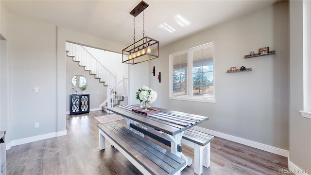 dining room with stairs, wood finished floors, and baseboards