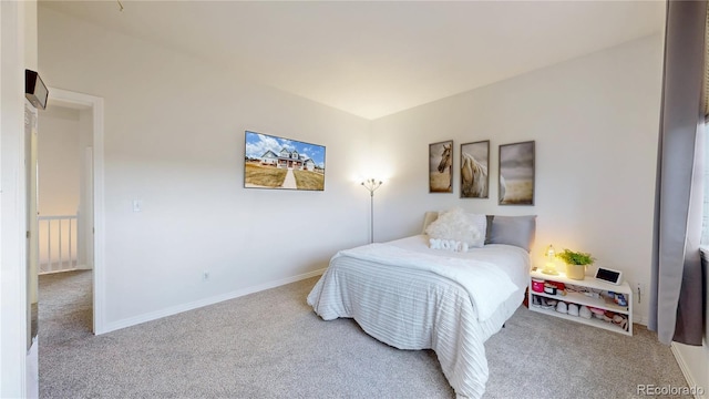 bedroom featuring light carpet and baseboards