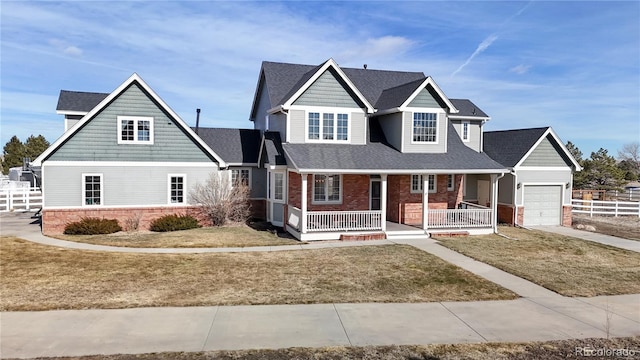 view of front of home featuring a garage, brick siding, fence, a porch, and a front yard