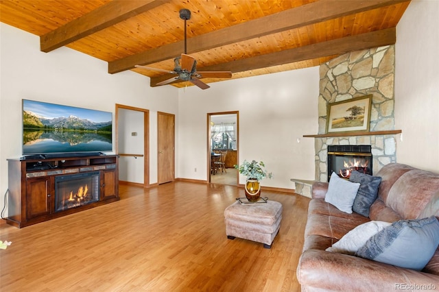 living room featuring a stone fireplace, ceiling fan, and light wood-type flooring