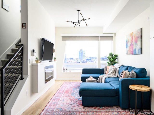 living room featuring wood-type flooring and an inviting chandelier