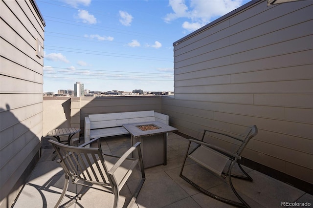 view of patio featuring an outdoor fire pit and a city view