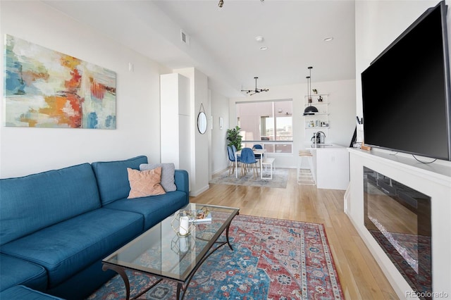 living room with light wood finished floors and visible vents