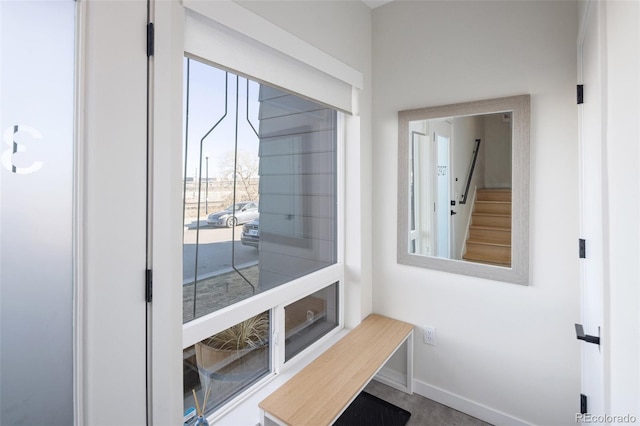 doorway to outside with stairway and baseboards