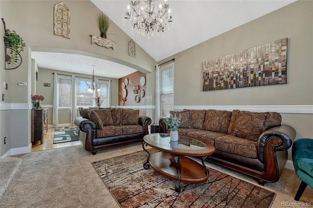 carpeted living room featuring baseboards, high vaulted ceiling, arched walkways, a notable chandelier, and a textured ceiling