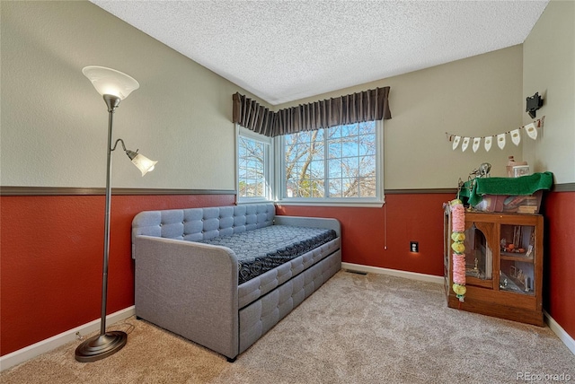 carpeted bedroom with baseboards and a textured ceiling