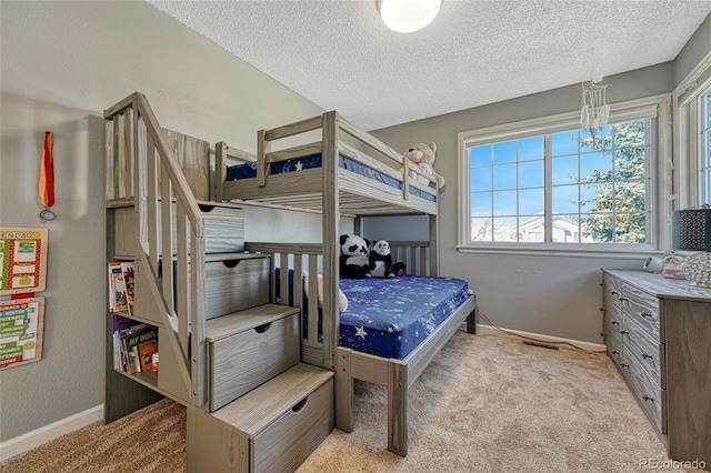 carpeted bedroom featuring baseboards and a textured ceiling