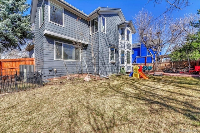 rear view of house with a fenced backyard and a yard