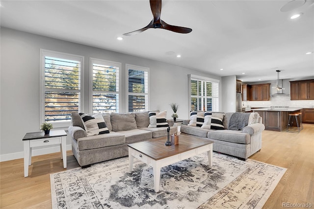 living room featuring light hardwood / wood-style flooring and ceiling fan