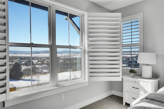 unfurnished bedroom featuring multiple windows, carpet, and a mountain view