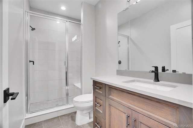 bathroom featuring vanity, walk in shower, tile patterned floors, and toilet