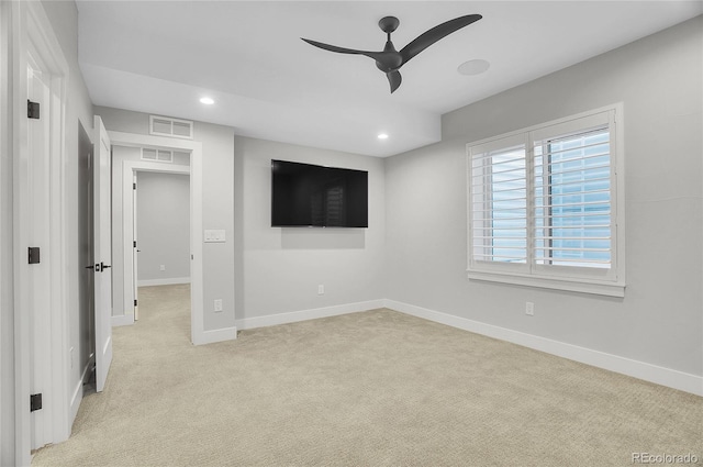 spare room with ceiling fan and light carpet