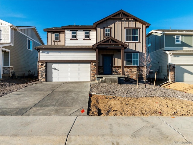 craftsman-style home with board and batten siding, concrete driveway, stone siding, and an attached garage