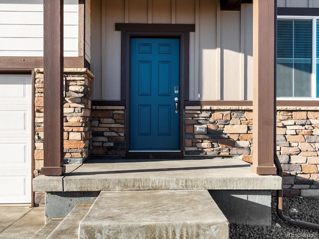 property entrance with stone siding and an attached garage