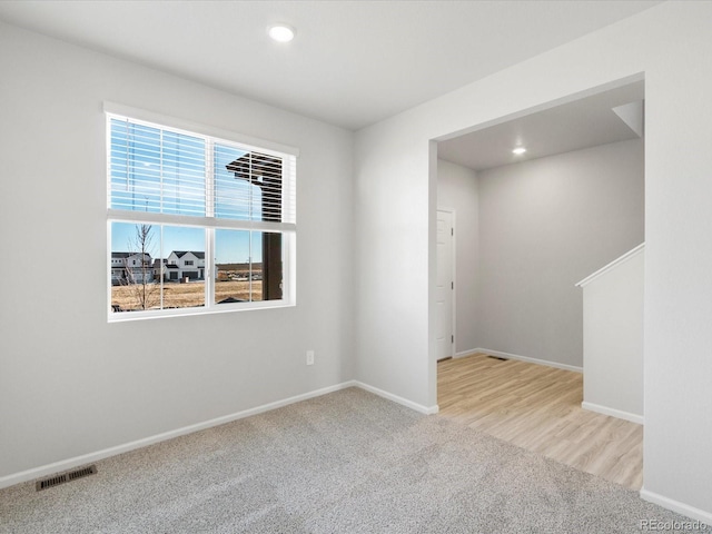 empty room featuring carpet, visible vents, baseboards, and recessed lighting