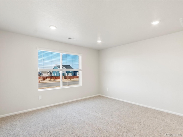 carpeted empty room featuring recessed lighting, visible vents, and baseboards