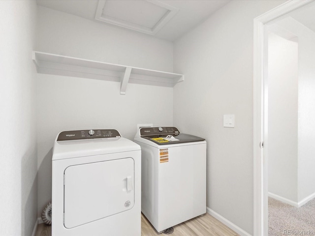 laundry area with light wood-style flooring, attic access, separate washer and dryer, laundry area, and baseboards