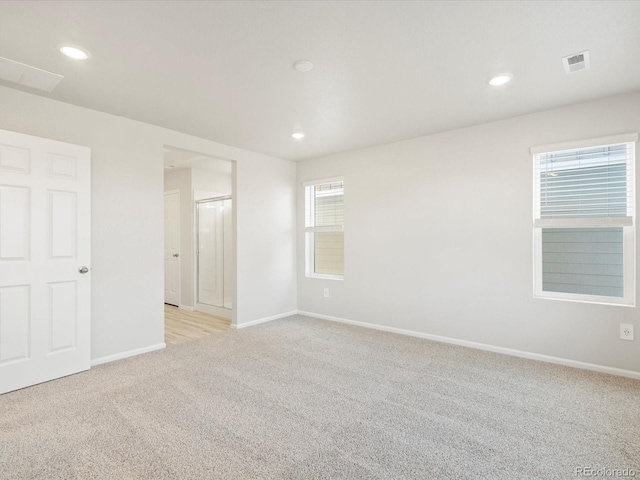 unfurnished room with recessed lighting, baseboards, visible vents, and light colored carpet