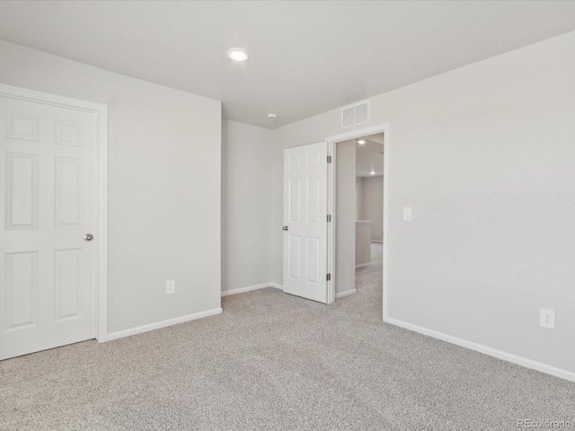 unfurnished bedroom with baseboards, visible vents, and light colored carpet