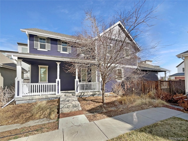 view of front of home featuring covered porch and fence