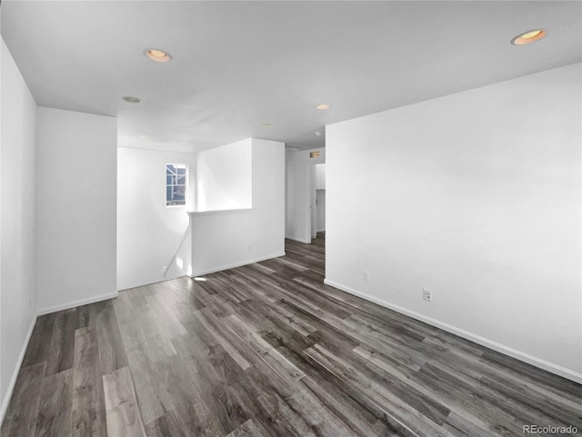 empty room with recessed lighting, baseboards, and dark wood-style floors