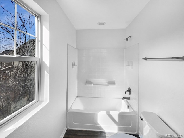 full bathroom with toilet, wood finished floors, and washtub / shower combination