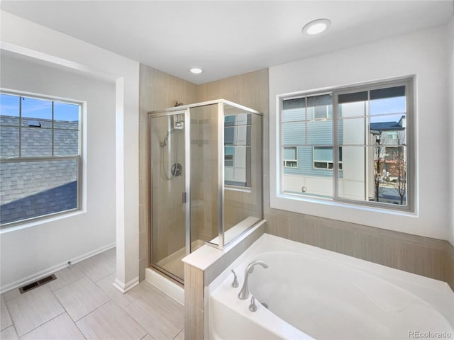bathroom featuring baseboards, visible vents, recessed lighting, a stall shower, and a bath