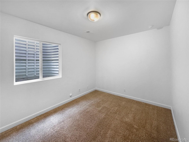 carpeted spare room featuring visible vents and baseboards