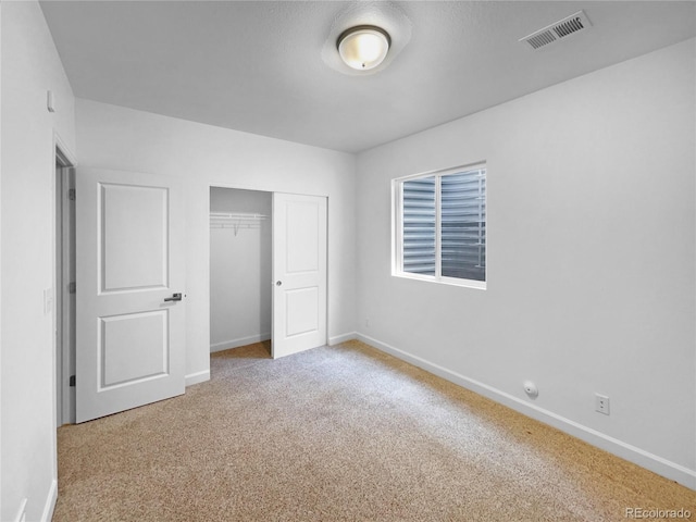 unfurnished bedroom featuring a closet, visible vents, baseboards, and carpet floors