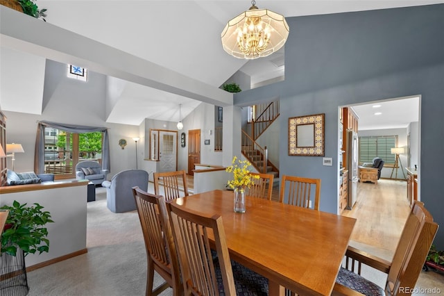 18 Blue Sage, Littleton, CO 80127 - dining area featuring a chandelier, high vaulted ceiling, stairs, and light colored carpet