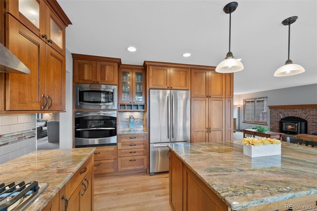 18 Blue Sage, Littleton, CO 80127 - kitchen featuring appliances with stainless steel finishes, brown cabinetry, decorative backsplash, light stone counters, and recessed lighting