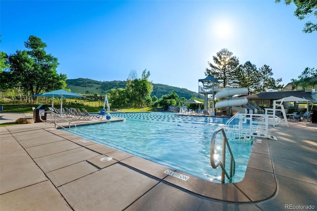 18 Blue Sage, Littleton, CO 80127 - community pool featuring a water slide, a patio, and a mountain view