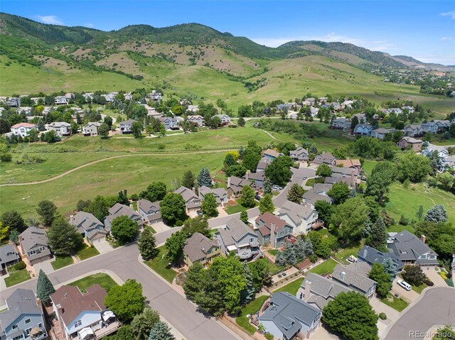 18 Blue Sage, Littleton, CO 80127 - aerial overview of property's location with nearby suburban area and a mountainous background