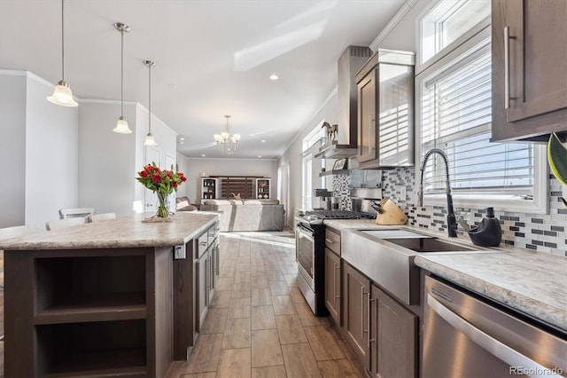 kitchen featuring stainless steel appliances, a center island, an inviting chandelier, hanging light fixtures, and dark brown cabinetry