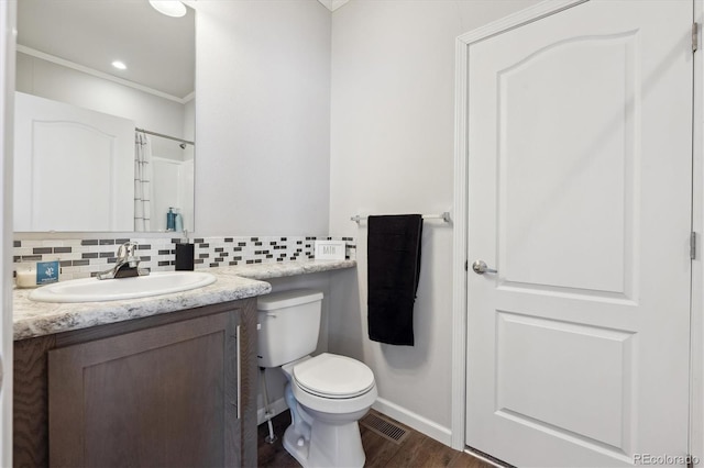 bathroom with toilet, walk in shower, decorative backsplash, wood-type flooring, and vanity