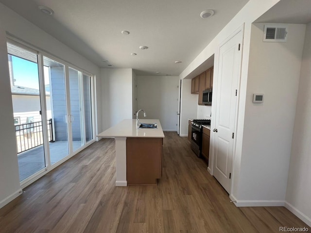 6648 N Nepal Ct, Aurora, CO 80019 - kitchen with appliances with stainless steel finishes, a sink, baseboards, wood finished floors, and recessed lighting