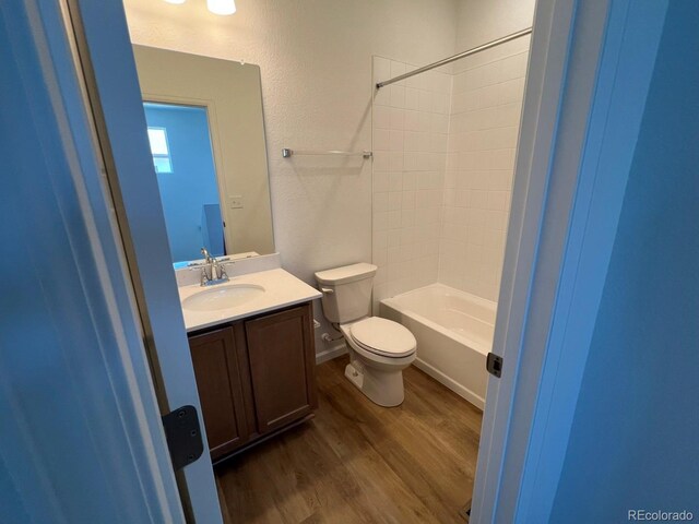 6648 N Nepal Ct, Aurora, CO 80019 - bathroom featuring wood finished floors, toilet, vanity, and shower / bath combination