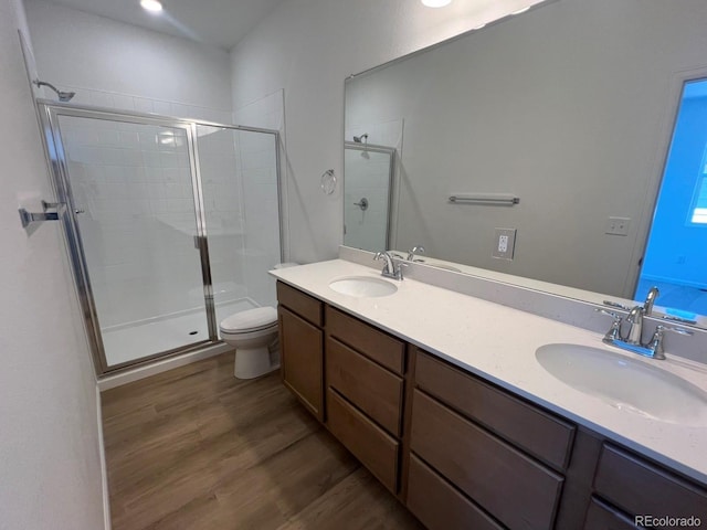 6648 N Nepal Ct, Aurora, CO 80019 - bathroom with a shower stall, wood finished floors, toilet, and double vanity