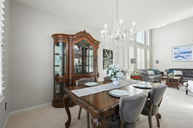 carpeted dining space featuring baseboards and an inviting chandelier